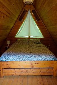 a bedroom with a bed in a wooden cabin at Camp Vrbas in Rekavice