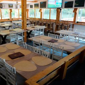 a dining room with wooden tables and chairs at Camp Vrbas in Rekavice