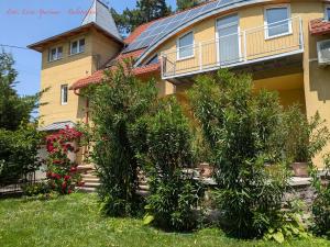 a house with trees in front of a building at Lívia Apartman in Balatonfüred