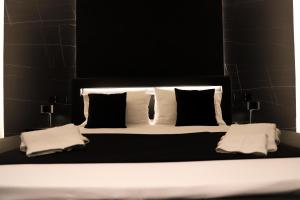 a large bed with black and white pillows at 115 Luxury Suite - Privitera in Grammichele
