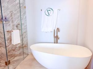 a white bath tub in a bathroom with a shower at Endless Ocean Views Luxury Bolongo Escape in Higuera Blanca
