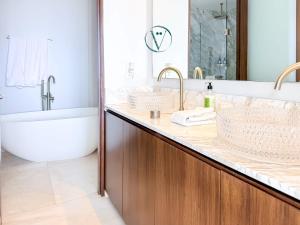 a bathroom with two sinks and a bath tub and a bath tub at Endless Ocean Views Luxury Bolongo Escape in Higuera Blanca