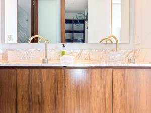 a bathroom with two sinks and a mirror at Endless Ocean Views Luxury Bolongo Escape in Higuera Blanca
