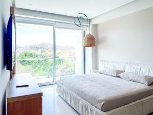a bedroom with a bed and a large window at Endless Ocean Views Luxury Bolongo Escape in Higuera Blanca +63 photos