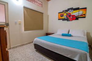 a bedroom with a bed with a painting on the wall at Hotel Montanar HOME in La Dorada