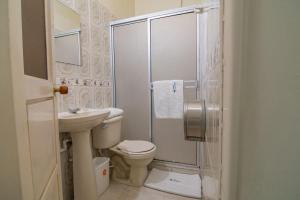 a bathroom with a shower and a toilet and a sink at Hotel Montanar HOME in La Dorada +17 photos