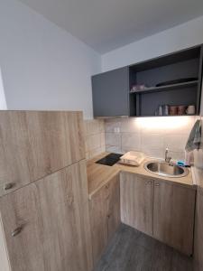 a kitchen with wooden cabinets and a sink at Apartmani Račeta in Kotor