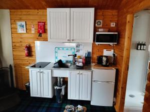 a kitchen with white cabinets and a sink at Emili Fois in Tore