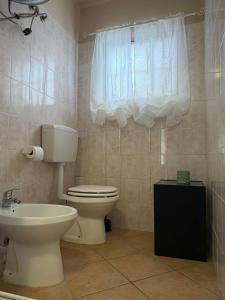 a bathroom with a toilet and a sink and a window at Il Rustico di Calosso in Calosso