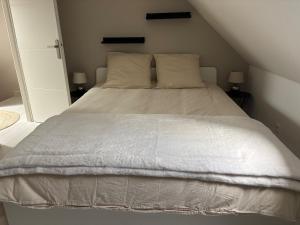 a bedroom with a white bed with two pillows at La Dune Dorée Escapade Croteloise in Le Crotoy +4 photos