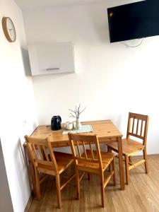 a wooden dining room table with chairs and a tv at Big Foot by MANGO Food&Bar in Karwia