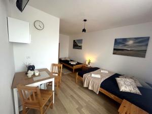 a bedroom with a bed and a table and a desk at Big Foot by MANGO Food&Bar in Karwia