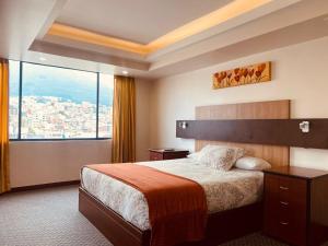 a hotel room with a bed and a large window at Los Angeles Stay Inn in Quito