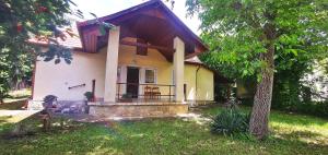 a small yellow and white house with a porch at Ildi nyaraló in Gárdony