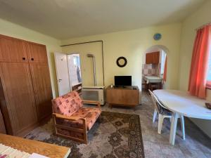 a living room with a table and a chair at Ildi nyaraló in Gárdony