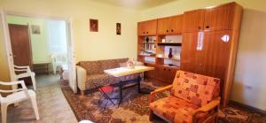 a living room with a couch and a table and a chair at Ildi nyaraló in Gárdony