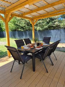a black table and chairs on a wooden deck at Balatoni Horizont Vendégház in Balatonakarattya
