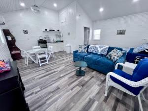 a living room with a blue couch and a table at Romantic Tea Cottage with Deck and Nature in Cape Girardeau
