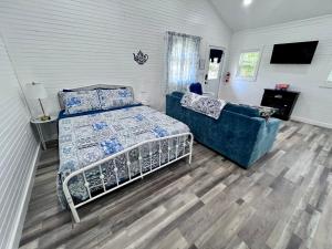 a bedroom with a bed and a couch at Romantic Tea Cottage with Deck and Nature in Cape Girardeau +21 photos