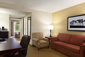 a hotel room with a couch and a table and chair at Country Inn & Suites by Radisson, Columbia at Harbison, SC in Columbia