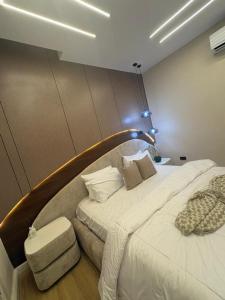 a bedroom with a large bed with a wooden headboard at Vluxuries in Lekki +6 photos