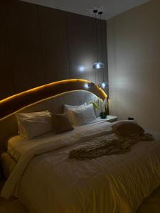 a bedroom with a large bed with white pillows at Vluxuries in Lekki