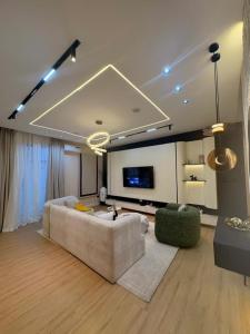 a living room with a couch and a flat screen tv at Vluxuries in Lekki
