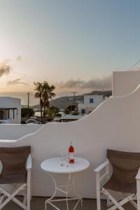 a white table with a bottle of wine on a balcony at Alexandra Suites - MYKONOS PORT in Mikonos