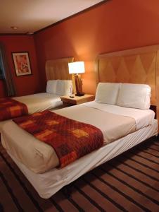 a hotel room with two beds and a lamp at Gated 2 Double Beds Studio with Full Kitchen 136 in Baton Rouge