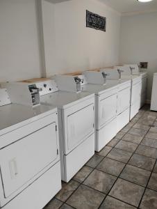 a row of white washing machines in a room at Gated 2 Double Beds Studio with Full Kitchen 136 in Baton Rouge