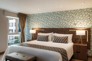 a bedroom with a large bed and a large window at Hotel Portón de la Cabrera in Bogotá