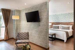 a bedroom with a bed and a tv on a wall at Hotel Portón de la Cabrera in Bogotá +74 photos
