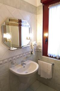 uma casa de banho com lavatório, espelho e toalhas em Pensione Al Pescatore em Termoli