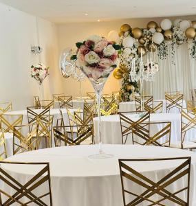 a room with tables and chairs with a bouquet of flowers at Domaine Malar in Guillerval