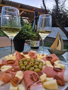 two glasses of wine and a plate of cheese and grapes at Balatoni Horizont Vendégház in Balatonakarattya +3 photos