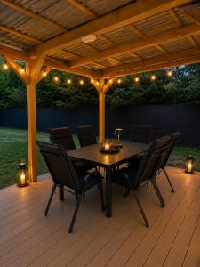 a wooden patio with a table and chairs on a deck at Balatoni Horizont Vendégház in Balatonakarattya