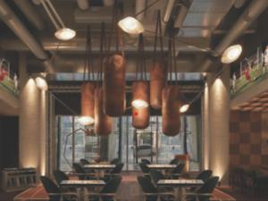 a dining room with tables and chairs and lights at Hotel Clark in Los Angeles