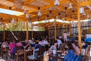 a group of people sitting at tables in a restaurant at Ekin Assos in Sokakagzi +28 photos