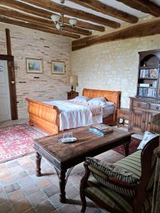 a bedroom with a bed and a coffee table at Chambre d'hotes de l'Ecu in Preuilly-sur-Claise