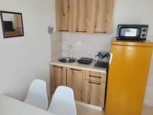 a small kitchen with a sink and a tv on top at Apartman Terrazza in Igalo