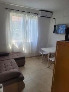a living room with a couch and a table and a window at Apartman Terrazza in Igalo