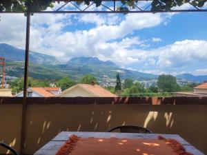 a table with a cake on a balcony with mountains at Apartman Terrazza in Igalo