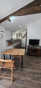 a room with a wooden table and a kitchen at Studio Mazalys-Entre Mer et Campagne in Crépon