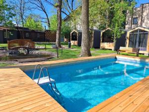 a swimming pool with a bench and a wooden deck at SmartVille Kyiv in Kyiv