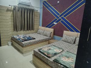 a room with two beds and a wall at Hotel Murlidhar in Chikāra +14 photos
