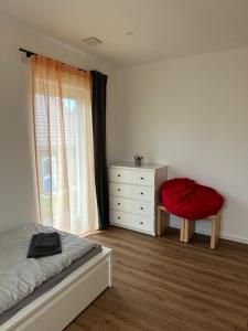 a bedroom with a bed and a dresser and a window at Samtenssonne in Samtens