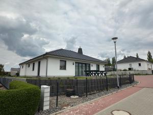a white house with a fence in front of it at Samtenssonne in Samtens