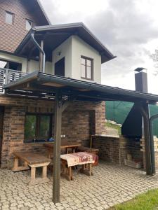 a pavilion with two picnic tables and benches on a patio at Chaloupka Jeřmanice in Jeřmanice