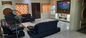 a living room with two chairs and a tv at Kembod hotel & suite in Ikeja