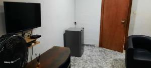 a room with a television and a table and a chair at Kembod hotel & suite in Ikeja